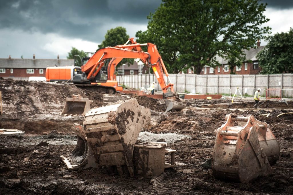 Graafmachines op bouwplaats, bewolkte lucht